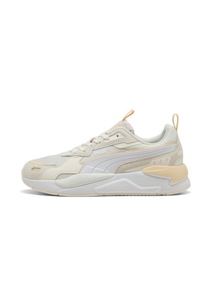 Beige sportieve schoenen met een textuurstof bovenwerk, witte accenten, een gevoerde kraag en een onderscheidend tussenzoolontwerp. Voorzien van een handige trekriem.