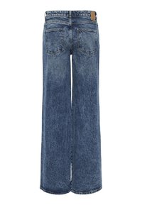 Plati blue džinsai su išblukusiu plovimu, turintys dvi užpakalines kišenes ir prekės ženklo etiketę ant juosmens. Sunkus audinys.