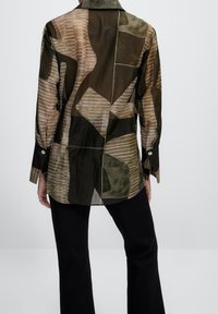 Transparente Langarmbluse mit einem abstrakten Patchwork-Design in erdigen Tönen von Grün und Beige, mit Kragen und knöpfbaren Manschetten.