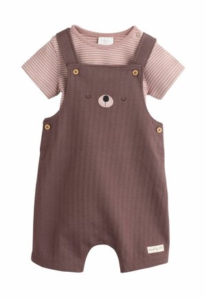 Baby-Strampler mit mauvefarbenen Latzhosen mit Bärengesicht und Holzknöpfen über einem staubrosa gestreiften Kurzarmshirt.
