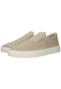 Béžové semišové nazouvací boty s elastickými bočními panely a bílou gumovou podrážkou. Hladký povrch, zaoblená špička, minimalistický design a detail značky.