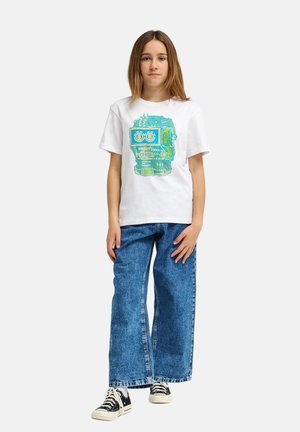 Biała bawełniana koszulka z niebieskim nadrukiem robota, zestawiona z wysokim stanem niebieskich dżinsów i czarnymi trampkami.