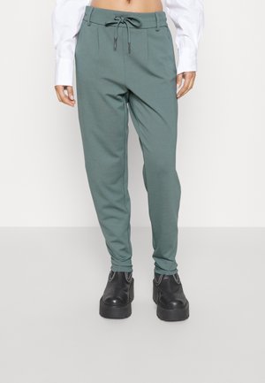 Grønne, afsmalnede sweatpants med elastisk talje og snøre. Blødt stof med sidelommer, parret med sorte platform sko.