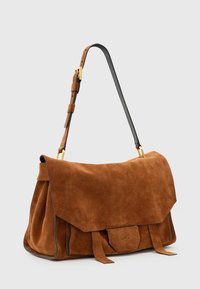 Borsa in pelle scamosciata marrone con chiusura a pattina, dettagli in pelle, tracolla regolabile e due legature frontali. Hardware dorato di notevole stile sulla tracolla.