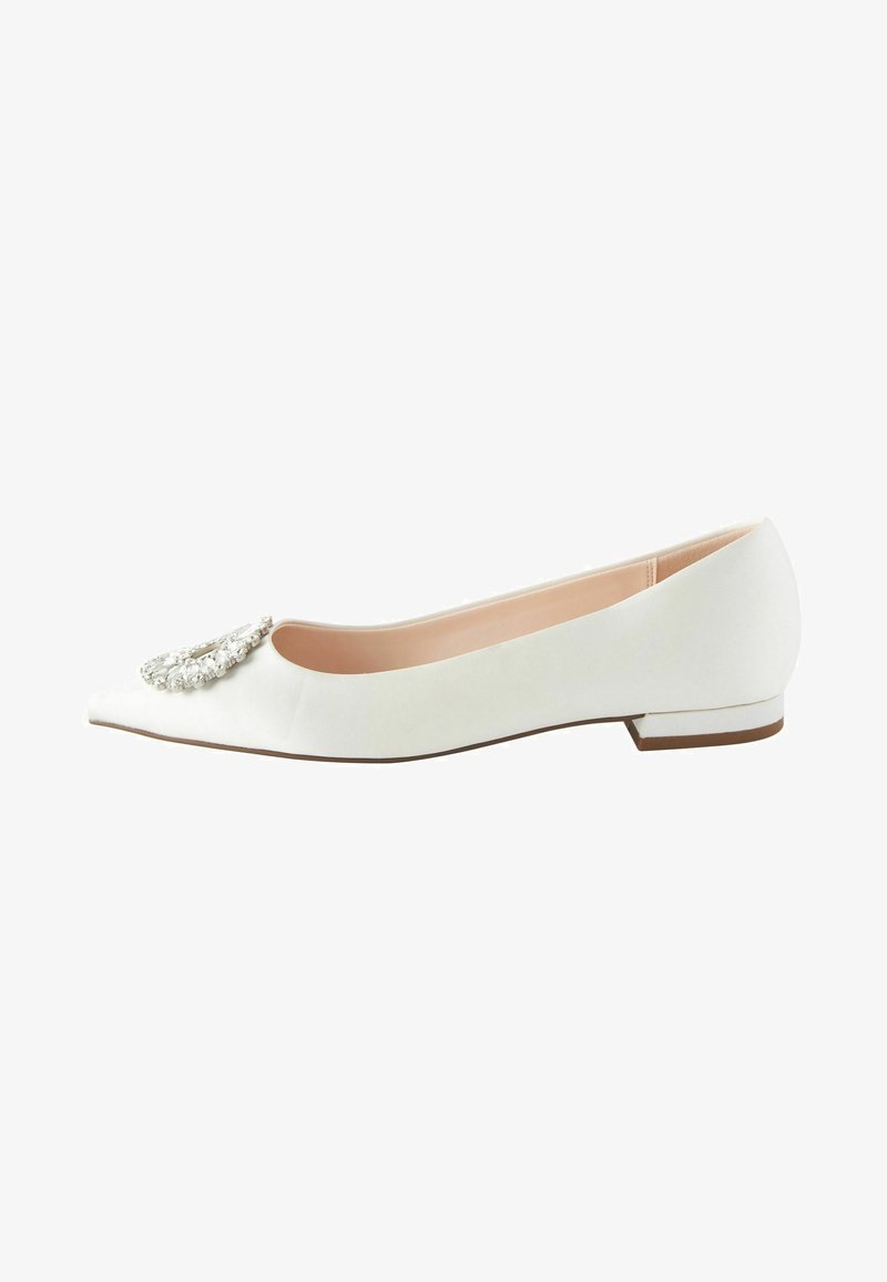 Chaussure plate en satin blanc avec un bout pointu, ornée d'un embellissement en cristal décoratif sur le devant et d'un petit talon carré.