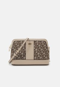 Sac bandoulière DKNY avec un devant en toile beige et marron à motif et un fond lisse. Il dispose de quincaillerie dorée et d'une bandoulière réglable.