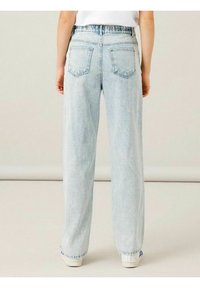 Ljusblå högmidjade vida jeans med en blekt finish, har två bakfickor och fransade fållar. Kombineras med vita sneakers.