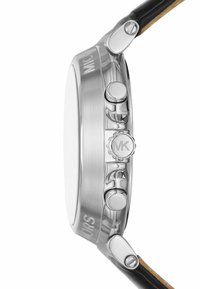 Vista lateral de un reloj de pulsera de acero inoxidable con tres botones, corona con el logo de MK y correa de cuero negro fijada con tornillos.