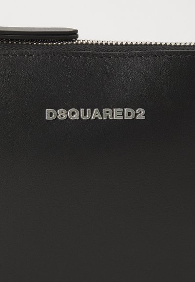 Must musta kott, millel on tekstureeritud pind. Omab hõbedast DSQUARED2 logo ja hõbedast tõmblukk, esitledes minimalismi disaini.