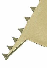 Manta beige con picos triangulares verdes a lo largo del borde, con una textura suave y aterciopelada y forma redondeada.