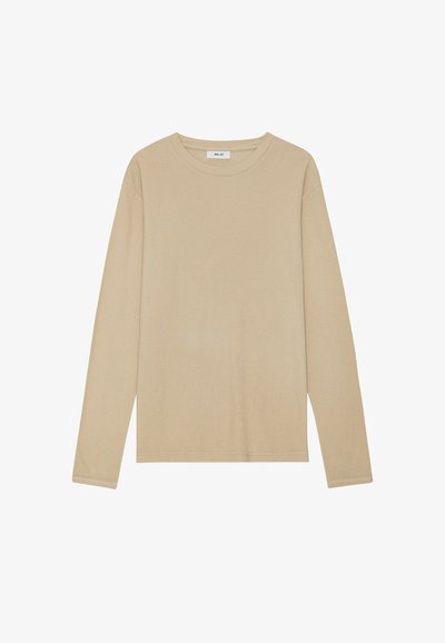 Vaaleanbeige pitkähihainen T-paita, jossa on pyöreä pääntie, sileä pinta ja minimalistinen muotoilu. Viimeistelty tavallisilla ompelu yksityiskohdilla.