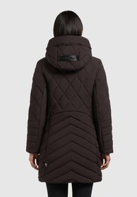 Brun quiltet puffjakke med hætte, der har et diagonalt mønster og et logo detalje på ryggen. Langærmede og en mellemlang design.