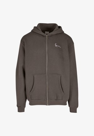 Szürke, cipzárral záródó kapucnis felső, bélelt kapucnival, elülső zsebekkel, bordázott mandzsettákkal és hem-el. A bal mellrészen egy kis fehér logó található.