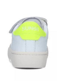 Sneaker in pelle bianca con un tallone grigio e giallo neon. Presenta una fascia in Velcro, punta arrotondata e una suola in gomma testurizzata.