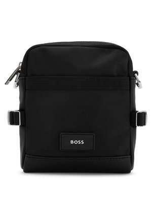 Sac bandoulière rectangulaire noir avec poche avant, bretelles latérales réglables et écusson logo BOSS centré sur le devant.