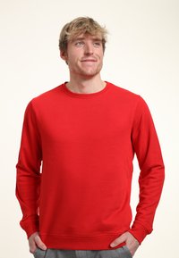 Röd långärmad sweatshirt i mjukt tyg. Har en rund halsringning och ribbade ärmslut, med en slät ytstruktur och utan mönster.
