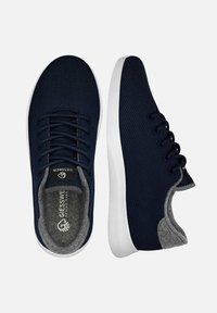 Baskets en maille bleu marine avec semelles blanches, comportant six œillets, une doublure grise et un logo sur la languette. Design léger et respirant.