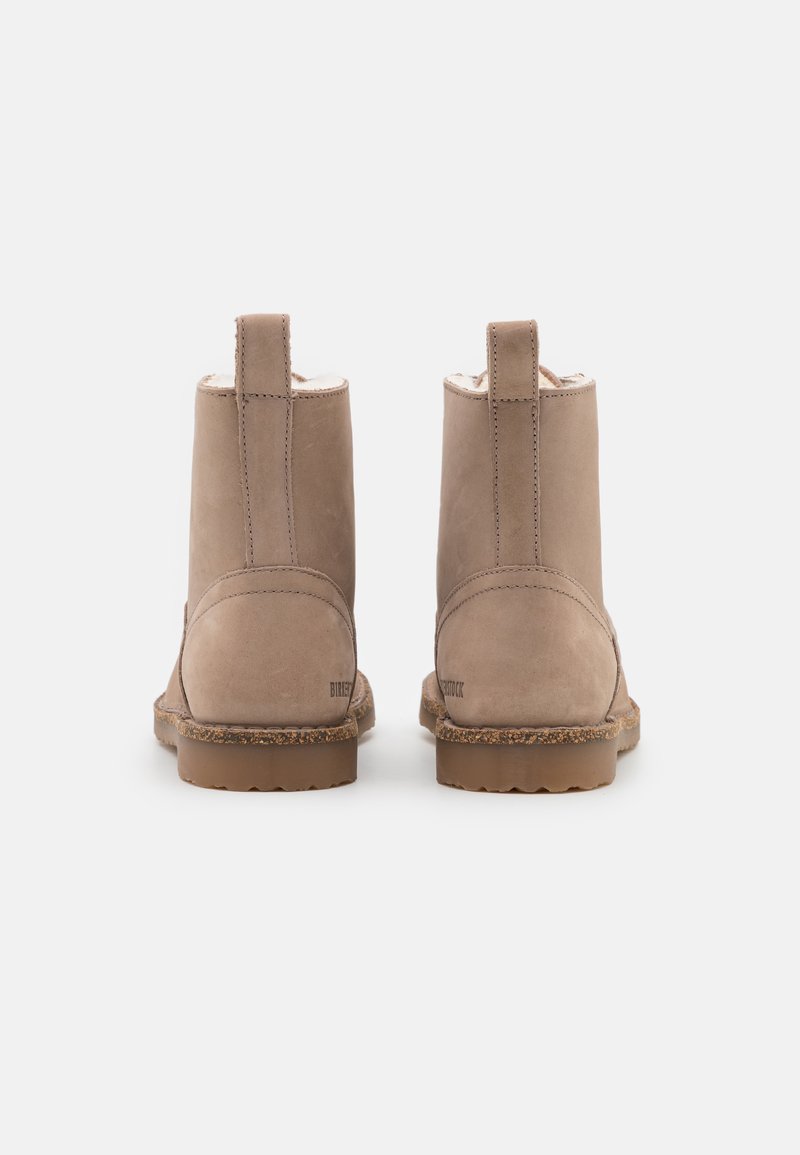 Beige Wildleder-Ankle Boots mit einer strukturierten Oberfläche, weicher Innenausstattung und einer strapazierfähigen Gummisohle. Verfügt über einen kleinen Zugtab hinten.