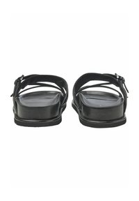Svarta sandaler med platt sula, öppen bakdel och korsade remmar. Det övre materialet har en slät yta med en minimalistisk design.