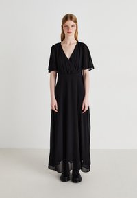 Black maxi dress with a deep V-neck, short flutter sleeves, and a flowing chiffon skirt, featuring a fitted bodice and subtle draping.
