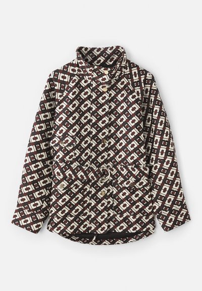 Prinditud jakk pruunis ja kreemjas värvitoonis, millel on geomeetriline muster, kõrge krae, pärlilaadsed nupud ja vöö, millel on metallring.