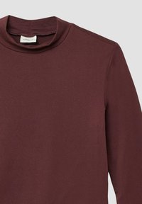 Bordeaux lange mouw top van zacht materiaal, met een hoge halslijn en een naadloos schouderontwerp. Glad textuur met minimale detailing.