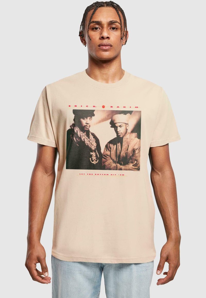 Beige bomulds t-shirt med et forsidegrafik af to mænd i sort-hvid med rød tekst "ERIC B. & RAKIM" og "LET THE RHYTHM HIT 'EM."