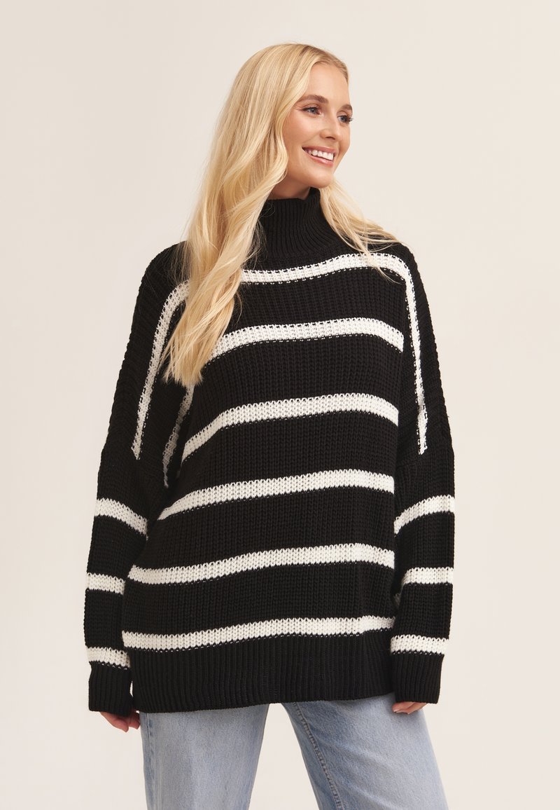 Black and white striped knit sweater features a high neck, loose fit, and ribbed cuffs. Soft texture with wide horizontal stripes.