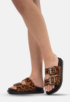 Sandali con stampa leopardata, parte superiore in suede marrone, suola piatta nera e dettagli in fibbia argentata. Design open-toe con doppie cinghie.