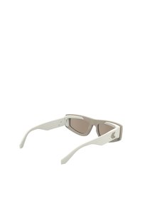 Sunglasses with a beige frame and white arms, featuring brown tinted lenses and a small logo on the side. Sleek, angular design.