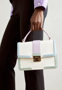 Bílá kabelka s krokodýlím vzorem s akcenty světle modré, levandulové a mátové barvy, zlatým kováním a strukturovaným tvarem. Disponuje horním madlem.