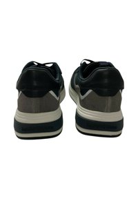 Sneakers sportivi con un mix di pelle scura e suede grigio, caratterizzati da una intersuola bianca e dettagli blu. Logo visibile sul tallone.