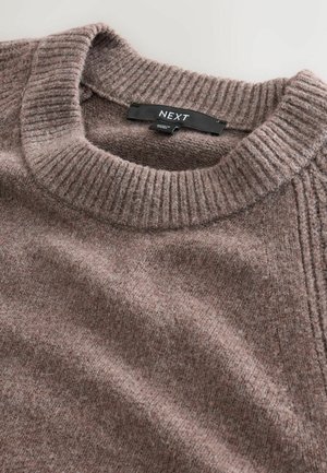 Brązowy sweter dzianinowy z okrągłym, ribbowanym dekoltem i fakturowanym materiałem. Oznaczony metką z logo "NEXT". W pozycji spłaszczonej.