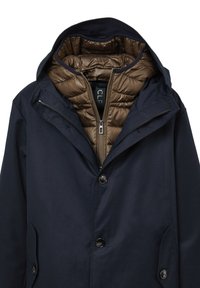 Giacca della marina con fodera sfoderabile in piumino marrone. Caratterizzata da un cappuccio, chiusura con zip, due tasche laterali e dettagli con bottoni.