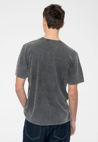 Gray cotton T-shirt with a classic crew neckline and short sleeves. Features a faded texture and a slightly curved hem.