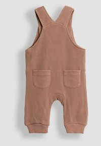 Gerippter, staubrosafarbener Latzanzug mit verstellbaren Trägern, zwei Fronttaschen und elastischen Bündchen. Weiche Textur, die für Komfort und einfachen Tragekomfort sorgt.