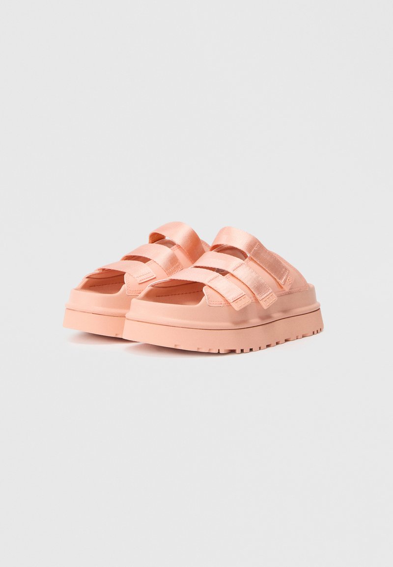 Pfirsichfarbene Plateausandalen mit breiten Stoffriemen. Dicke, strukturierte Sohle mit einem gerippten Muster und offenem Zehenbereich für Belüftung.