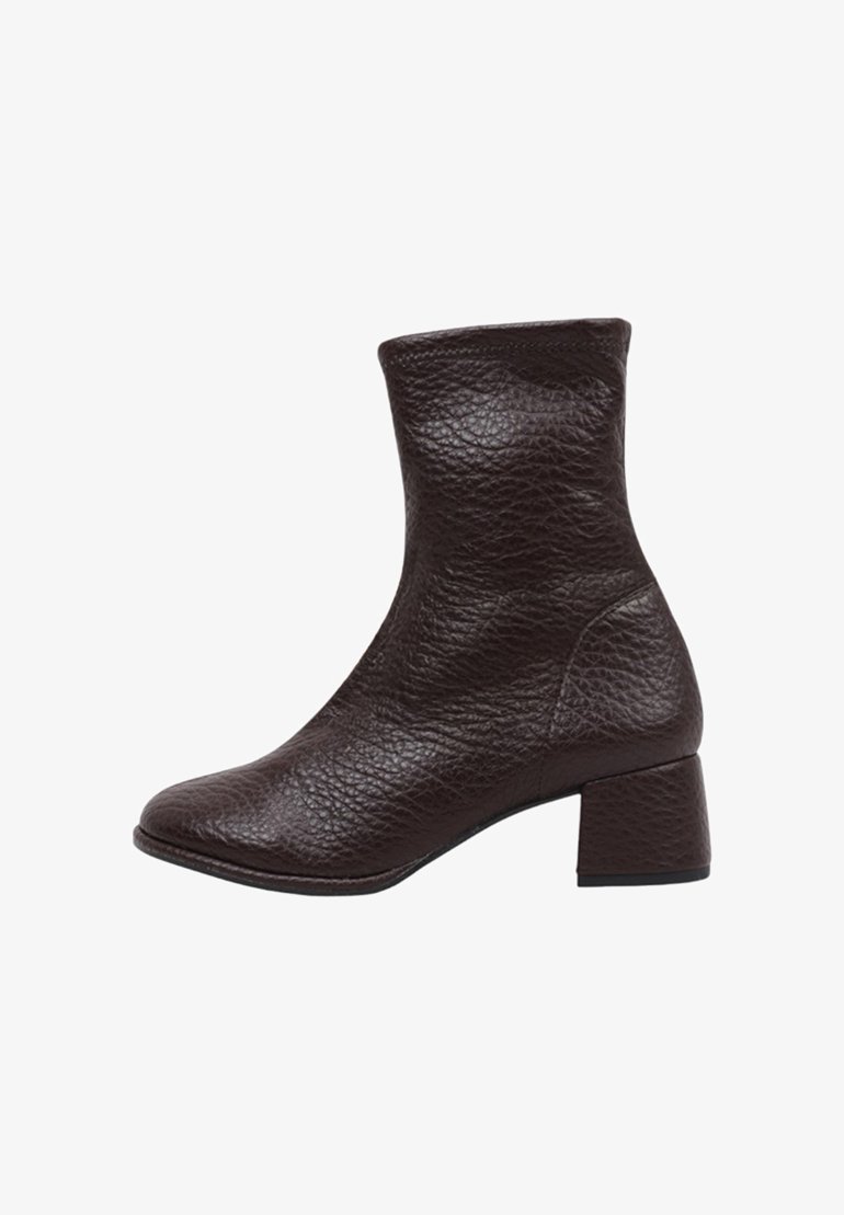 Bottine en cuir marron avec une finition texturée, bout carré et talon block. La bottine a un design ajusté et une doublure intérieure lisse.