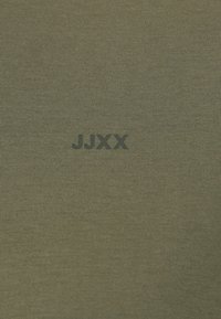 Olivovo zelené bavlnené tričko s vertikálnou rebrovanou textúrou a potlačeným logom "JJXX" v tmavozelenej farbe na prednej strane.