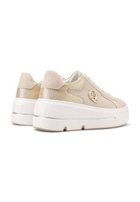 Sneaker beige con una parte superiore in pelle liscia e suede, dettagli metallici, suola piatta spessa bianca e marchio laterale.