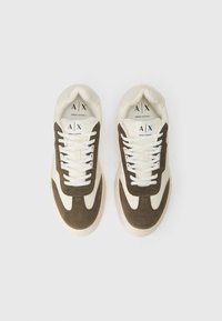 Et par beige og brune Armani Exchange sneakers med hvide snørebånd, set ovenfra på en hvid baggrund.