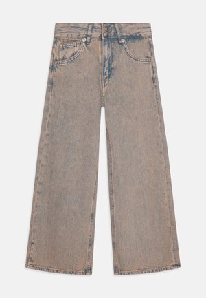 Heledad sinised laiad püksid, millel on kulunud välimus, kõrge vöökoht, viis taskut ja nähtavad õmblused.