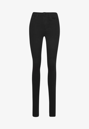 Black skinny jeans made from stretch fabric. Features five-pocket design, belt loops, and a front zip fly for closure. Smooth texture.