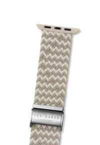 Correa de reloj de tela tejida en beige y crema con un patrón geométrico. El cierre metálico presenta el grabado "TED BAKER LONDON".