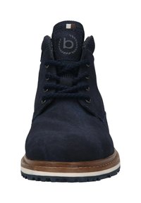 Marineblaue Wildleder-Ankle Boots mit runder Zehenform, sechs Ösen und strukturierten Schnürsenkeln. Mit einer hellbraunen Zwischensohle und einer strukturierten Gummisohle.