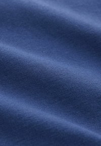 Tejido azul marino con una textura suave, que presenta un patrón de punto fino. El material parece suave y ligeramente elástico.