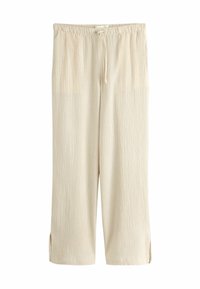 Pantalon beige à coupe ample avec taille élastique et cordon, tissu texturé, jambes droites et petites fentes latérales à l'ourlet.