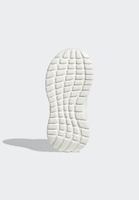 Suela de zapatilla blanca con un diseño texturizado y en patrón que presenta surcos y crestas para tracción. Bordes lisos y forma redondeada.