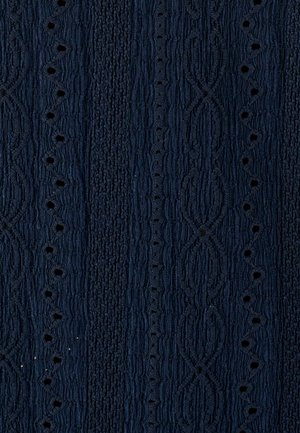 Tissu bleu marine texturé présentant des motifs en relief et des trous d' œillet décoratifs, affichant un design côtelé avec des détails complexes.