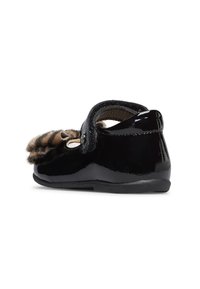 Scarpa in vernice nera con accenti in pelliccia sintetica, chiusura con strap in velcro, punta tonda e dettagli in stampa animale discreti sulla tomaia.
